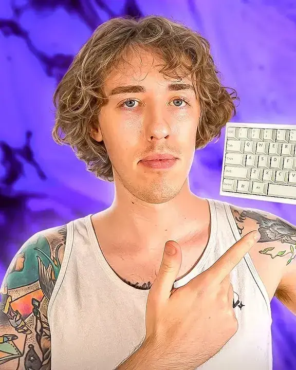 Tech reviewer in a white tank top points at the white keyboard he holds, purple backdrop